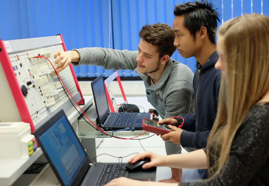 Lernende messen gemeinsam an einem elektrotechnischen Versuchsaufbau